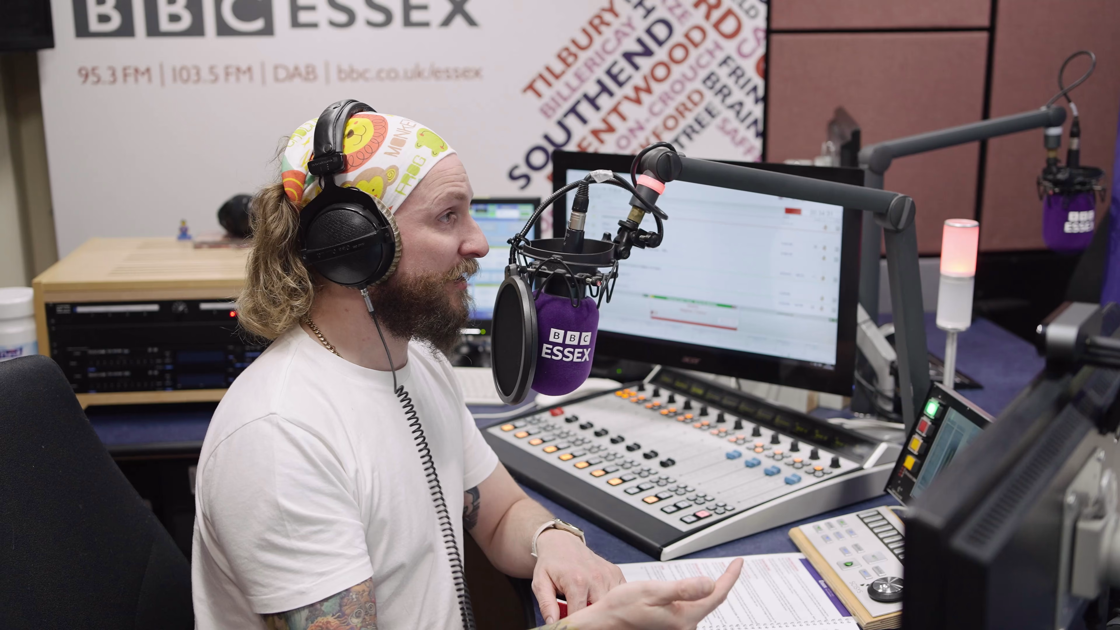 Radio presenter listening at the broadcast desk